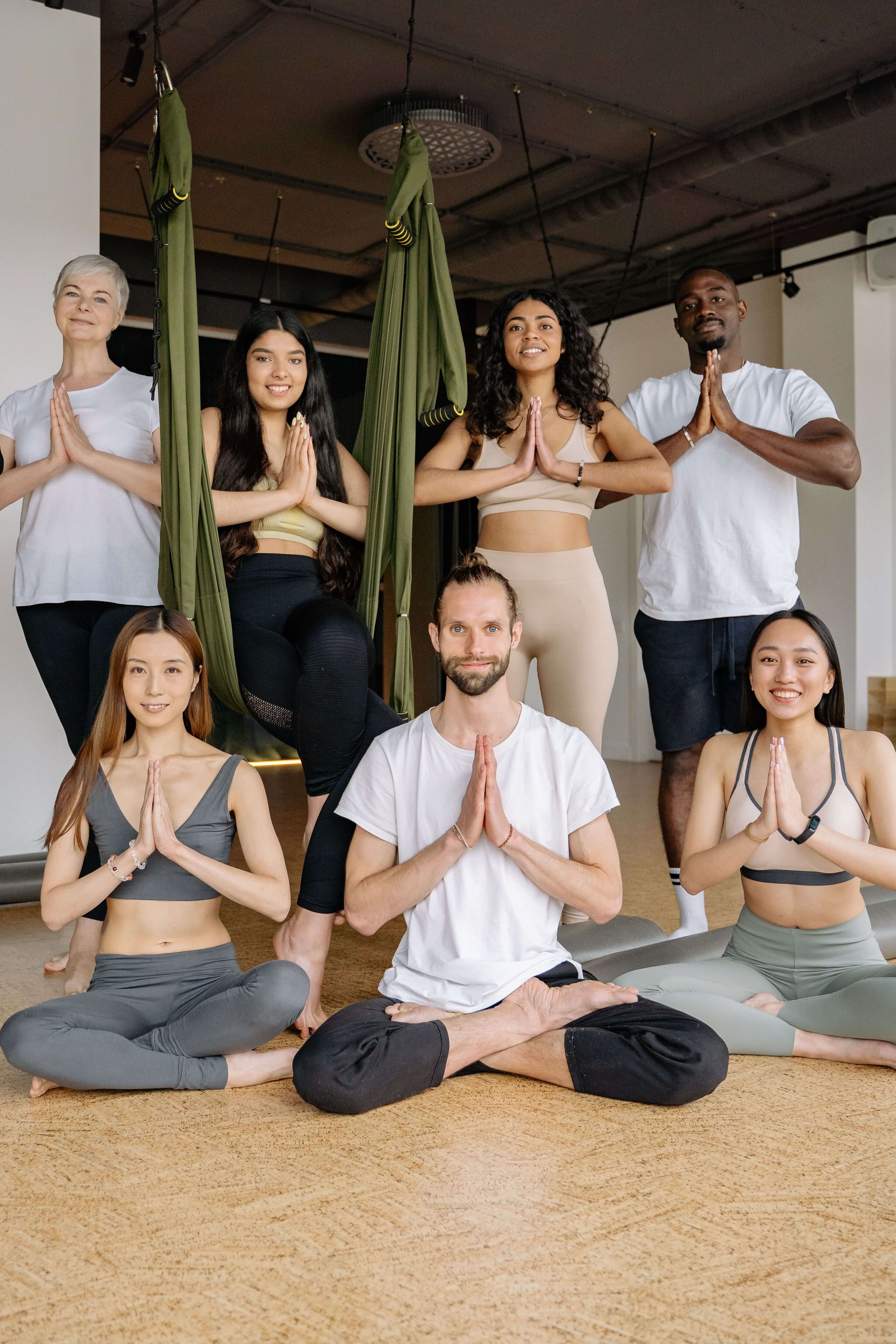 A multicultural group practicing yoga poses in an indoor studio setting